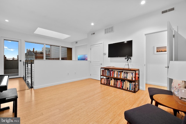 living area featuring baseboards, wood finished floors, visible vents, and recessed lighting