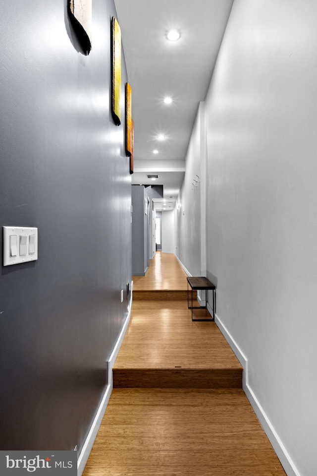 hallway featuring recessed lighting, wood finished floors, and baseboards