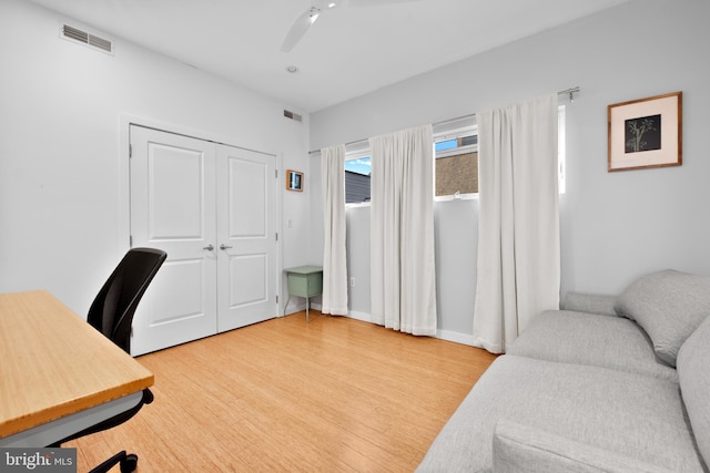 home office featuring ceiling fan, light wood-style flooring, visible vents, and baseboards