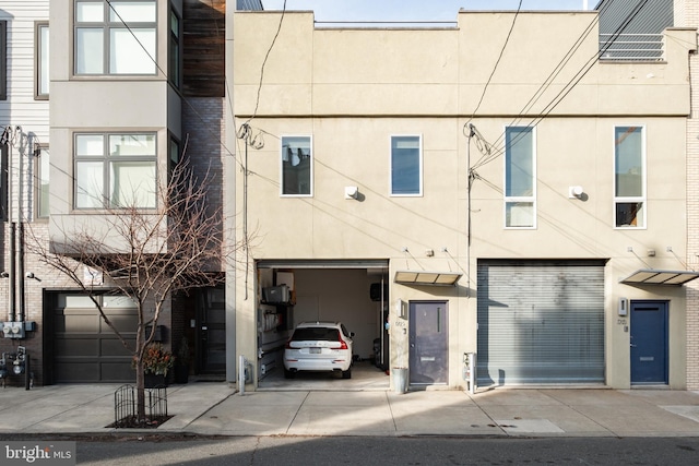 townhome / multi-family property with driveway and stucco siding