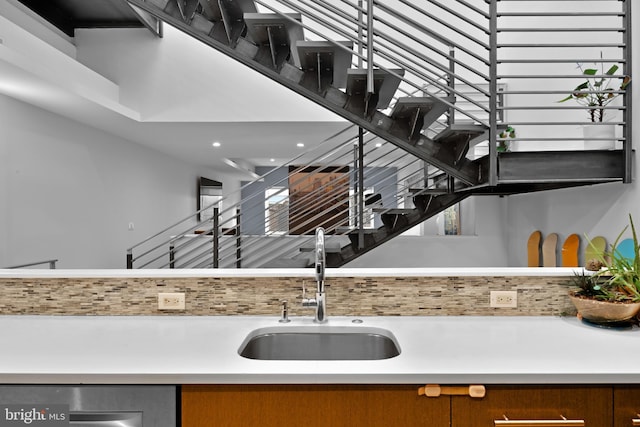 interior space featuring brown cabinetry, light countertops, a sink, and dishwasher