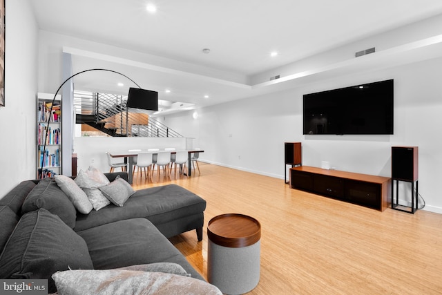 living area featuring stairs, recessed lighting, visible vents, and wood finished floors