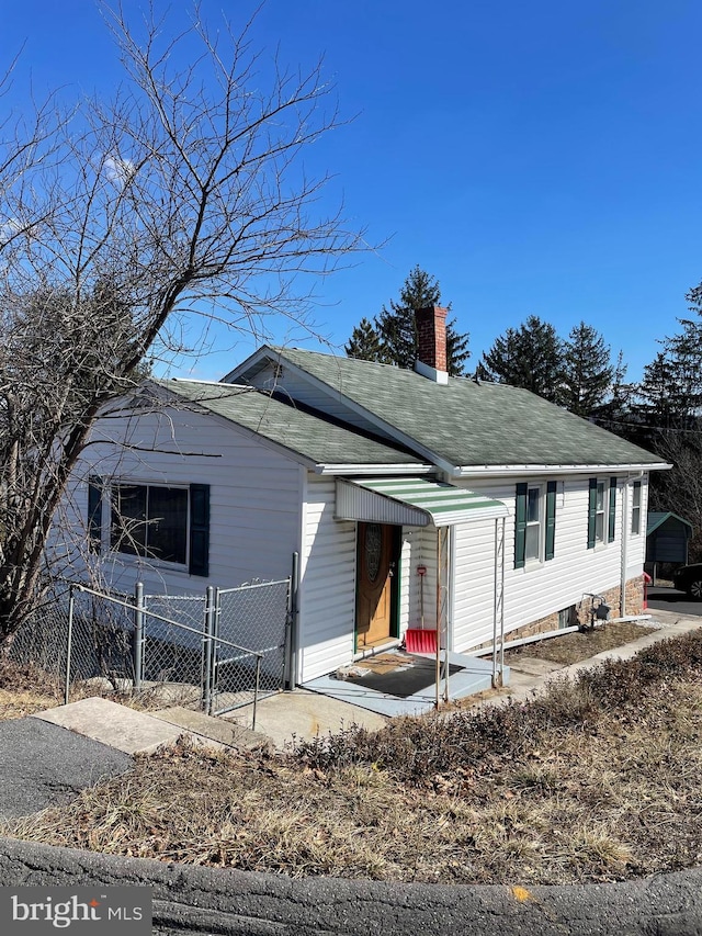 view of front of house featuring a chimney and fence