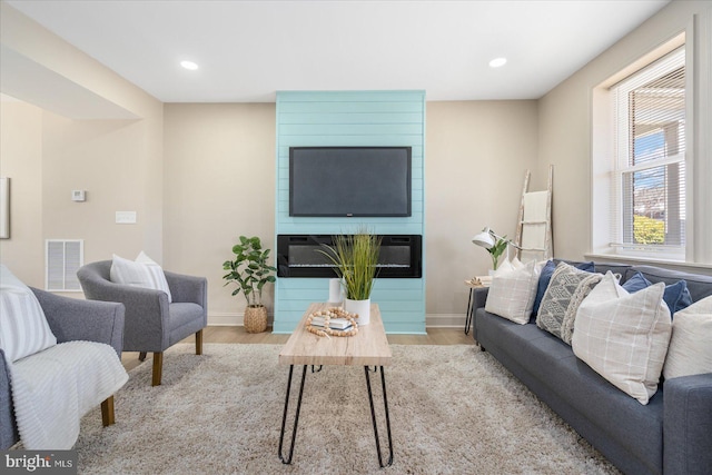 living area featuring recessed lighting, wood finished floors, and visible vents