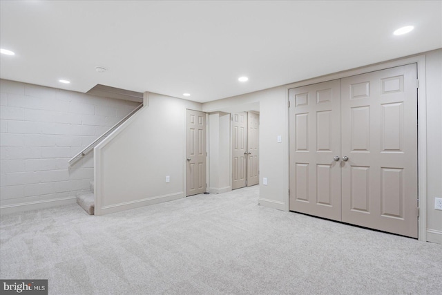 finished basement featuring stairway, recessed lighting, carpet, and baseboards