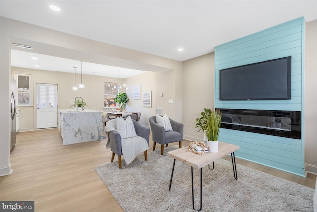 living room with recessed lighting, light wood-type flooring, and baseboards