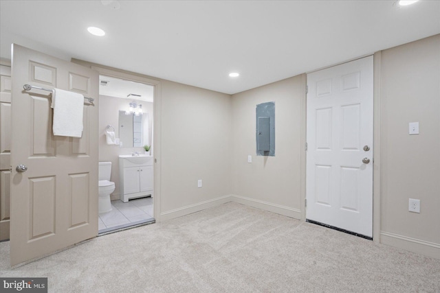 unfurnished bedroom with electric panel, carpet, baseboards, and a sink