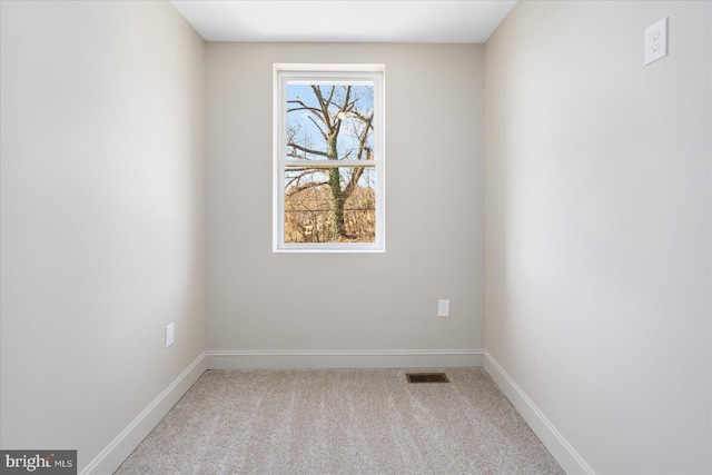 carpeted empty room featuring baseboards and visible vents