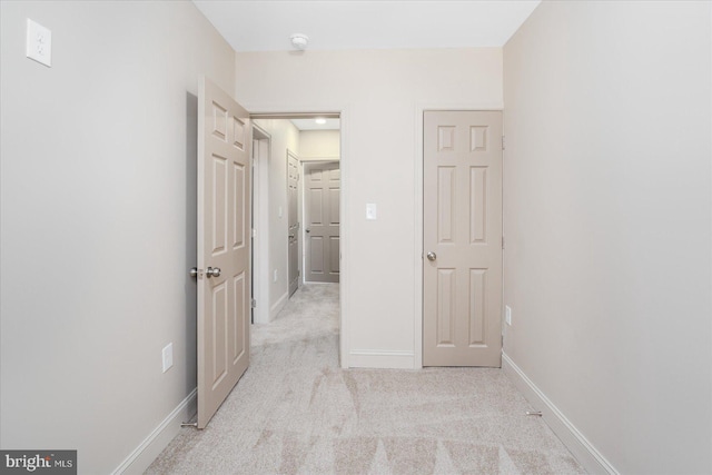 hall featuring carpet and baseboards