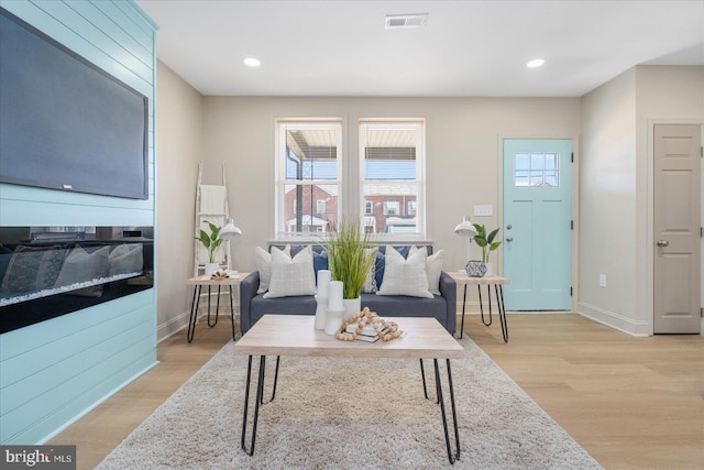 living room with plenty of natural light, visible vents, baseboards, and light wood-style floors