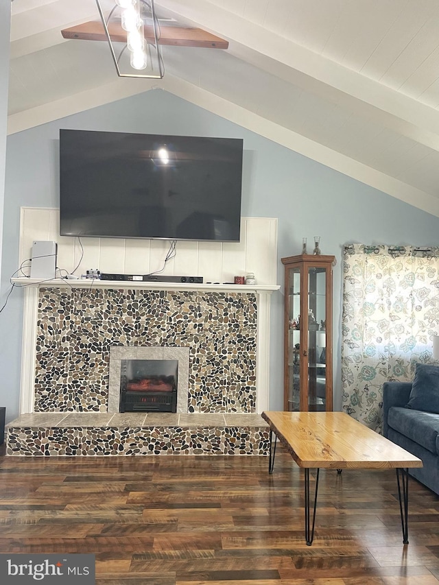 living area with ceiling fan, lofted ceiling with beams, wood finished floors, and a tile fireplace