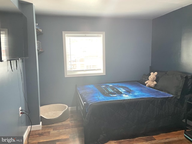 bedroom featuring baseboards and wood finished floors