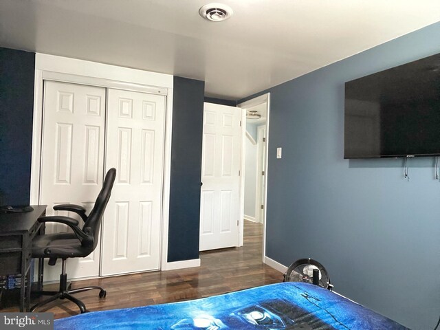 bedroom featuring visible vents, baseboards, a closet, and wood finished floors