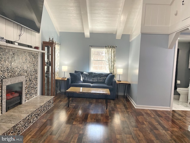 living room with beam ceiling, hardwood / wood-style flooring, wooden ceiling, baseboards, and a tile fireplace