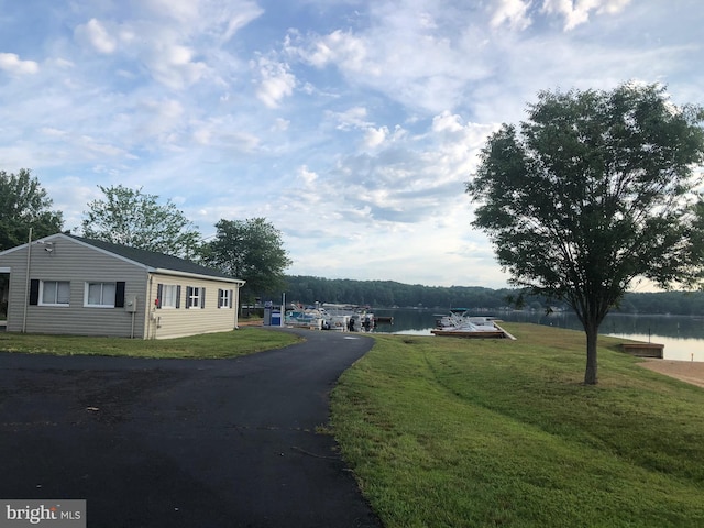 view of street featuring aphalt driveway and a water view