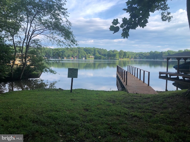 dock area featuring a lawn and a water view