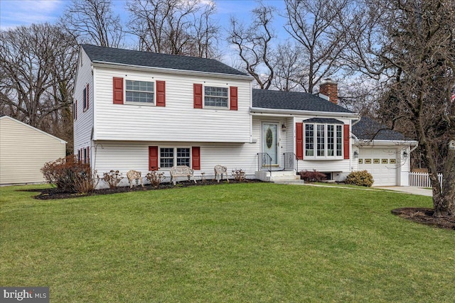 split level home featuring roof with shingles, an attached garage, a chimney, and a front lawn