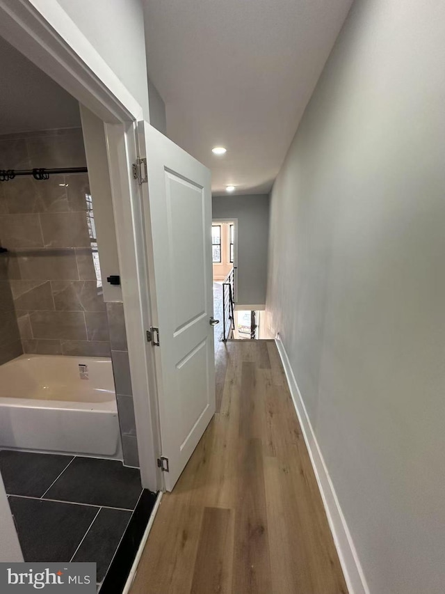 hallway featuring wood finished floors and baseboards