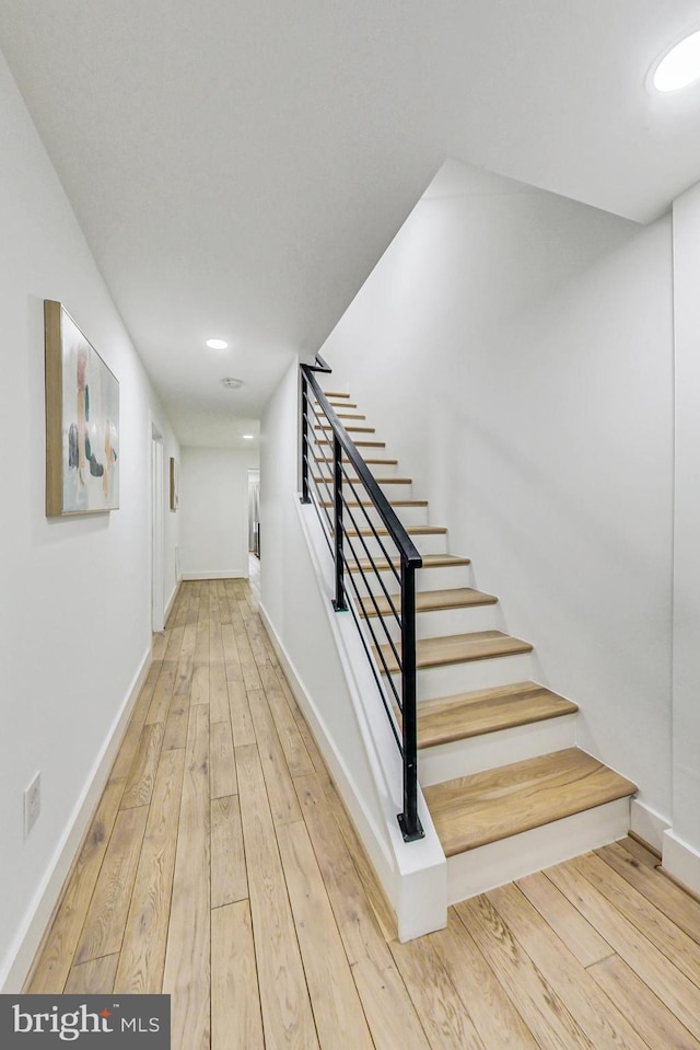 staircase featuring wood-type flooring, baseboards, and recessed lighting