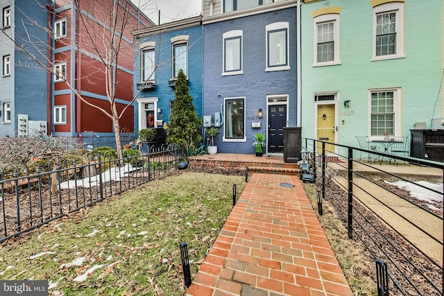 view of front of house featuring brick siding and fence