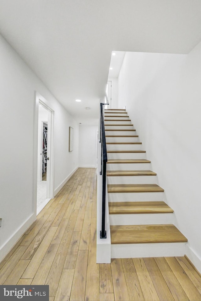stairway with recessed lighting, baseboards, and wood finished floors