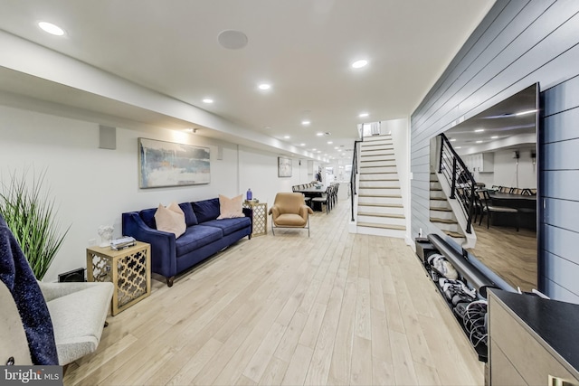 living area with light wood-style floors, recessed lighting, and stairway