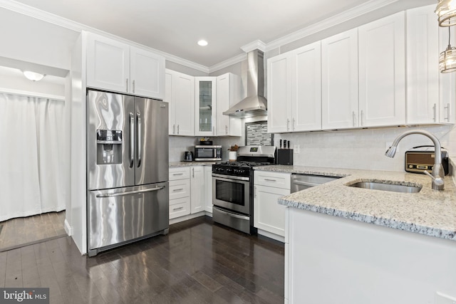 kitchen with white cabinetry, wall chimney exhaust hood, appliances with stainless steel finishes, and a sink