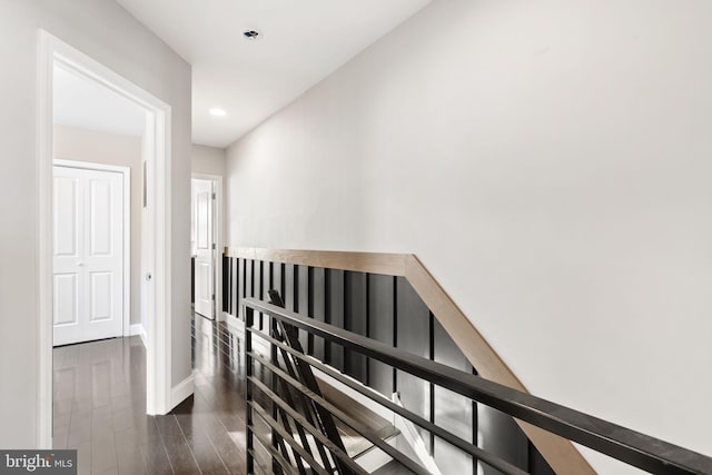 hall featuring baseboards, dark wood finished floors, an upstairs landing, and recessed lighting