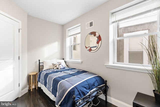 bedroom with dark wood-type flooring, visible vents, and baseboards