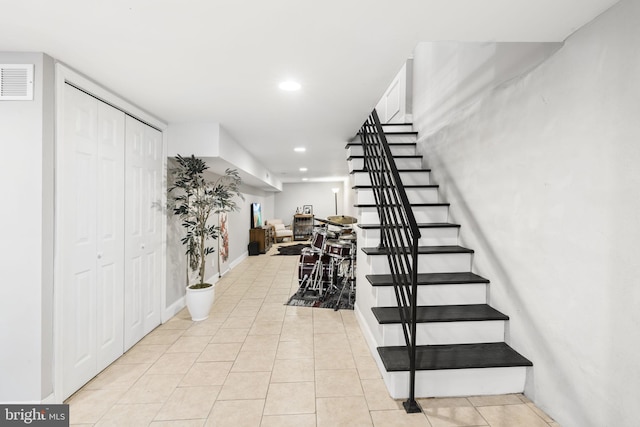 stairway featuring tile patterned flooring, visible vents, baseboards, and recessed lighting