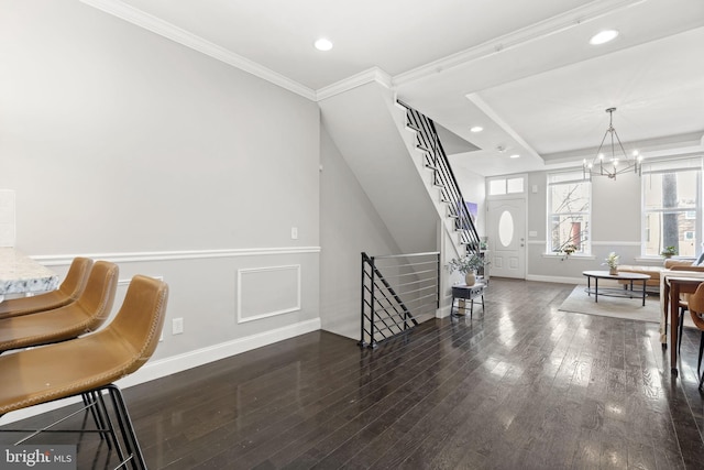 foyer with a notable chandelier, crown molding, recessed lighting, hardwood / wood-style floors, and stairs