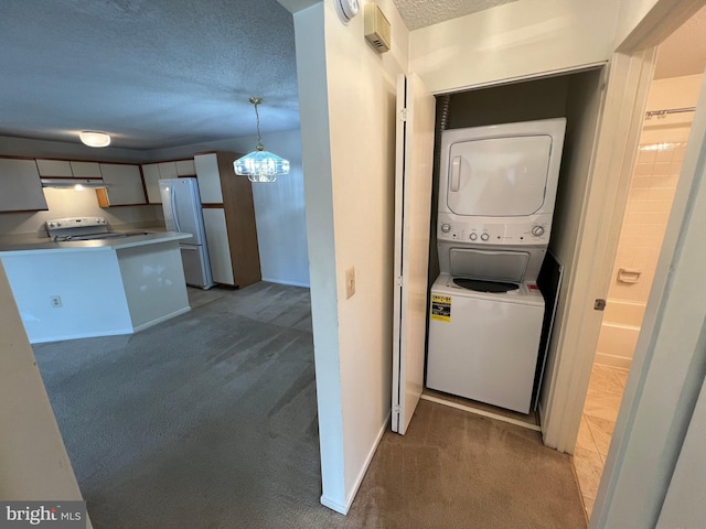 washroom featuring a textured ceiling, laundry area, stacked washing maching and dryer, and dark colored carpet