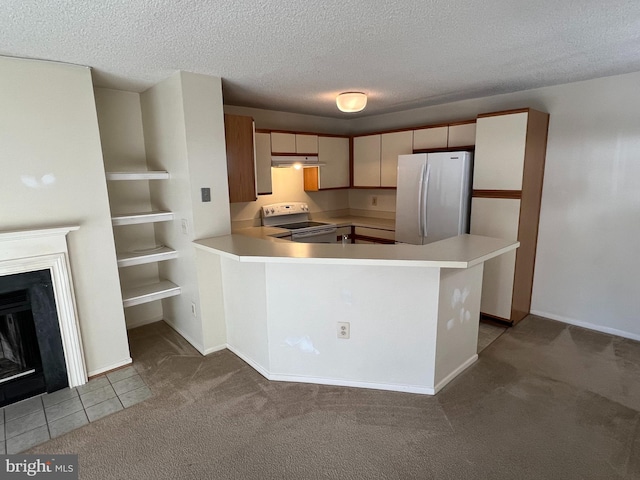 kitchen with freestanding refrigerator, light countertops, range with electric cooktop, and a peninsula