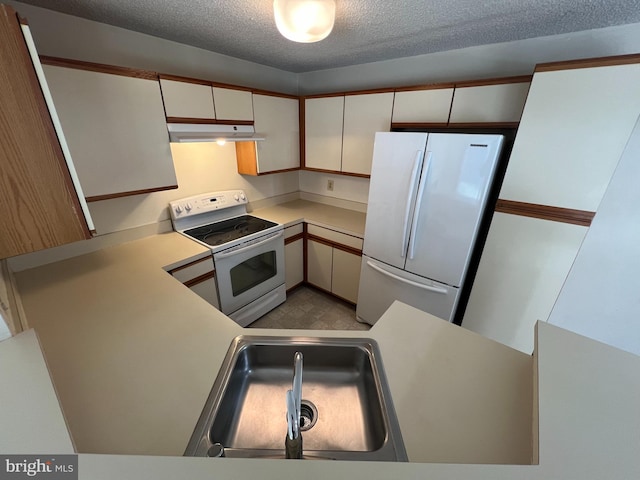 kitchen with light countertops, white appliances, white cabinets, and under cabinet range hood