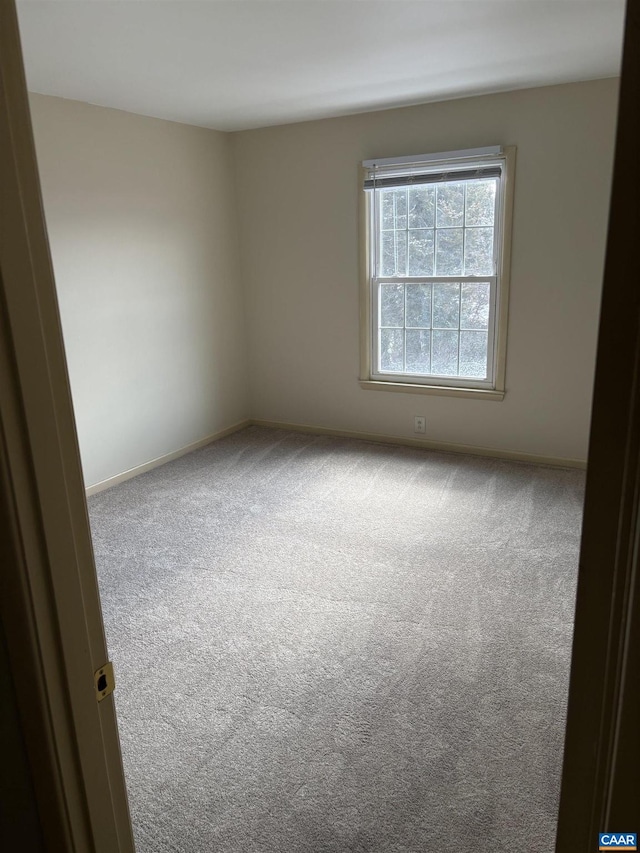 carpeted spare room with baseboards