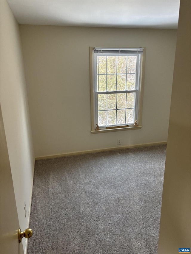 unfurnished room featuring carpet floors and baseboards