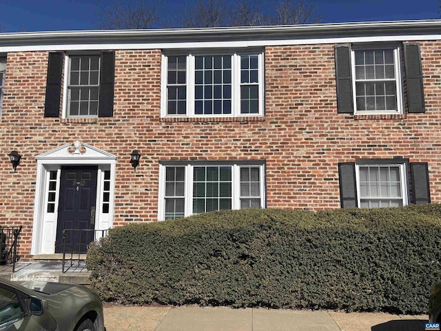 colonial-style house featuring brick siding