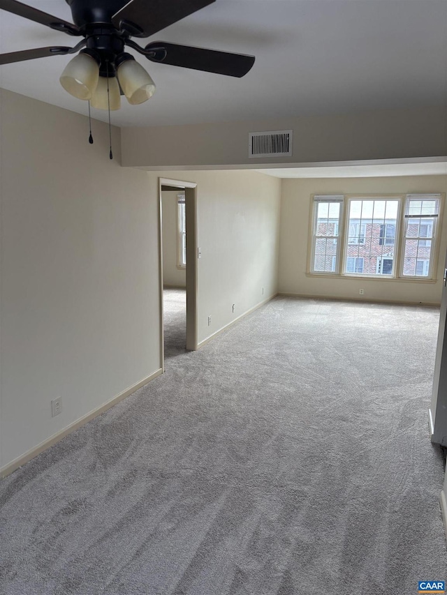 unfurnished room featuring ceiling fan, baseboards, visible vents, and light colored carpet