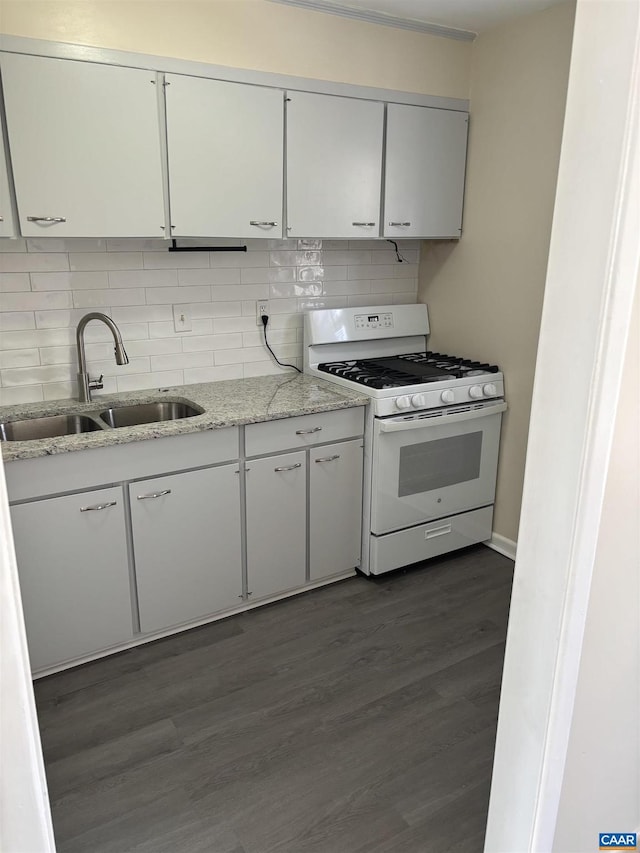 kitchen featuring white cabinets, white gas range, dark wood-type flooring, and a sink