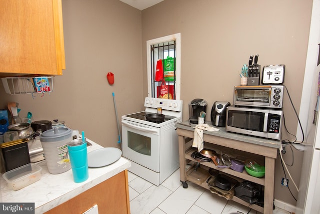 kitchen featuring a toaster, stainless steel microwave, marble finish floor, light countertops, and white range with electric cooktop