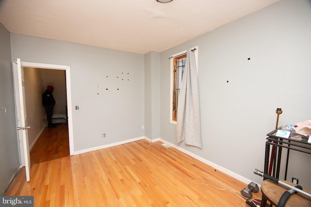 unfurnished room featuring visible vents, baseboards, and wood finished floors