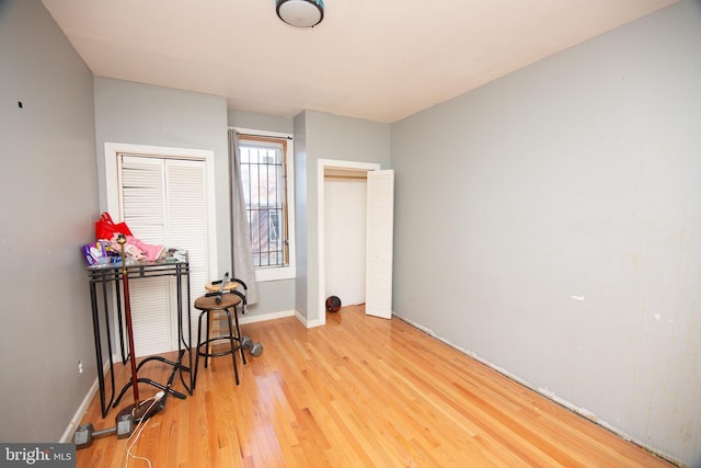 bedroom featuring wood finished floors, two closets, and baseboards