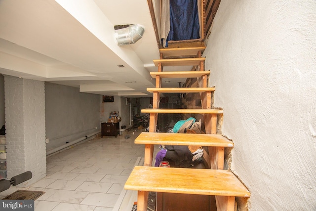 stairs with marble finish floor and a textured wall