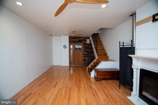 living area featuring recessed lighting, stairway, a fireplace with flush hearth, light wood-style floors, and a ceiling fan