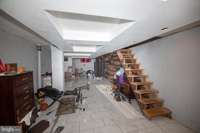 workout area featuring a tray ceiling, marble finish floor, and visible vents