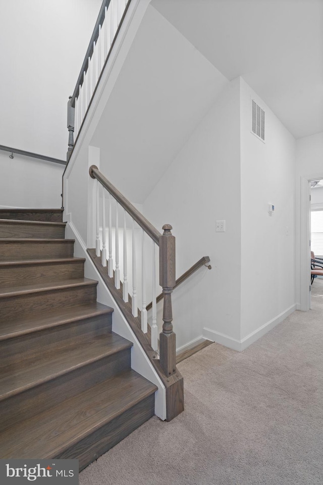 stairs with baseboards, visible vents, and carpet flooring