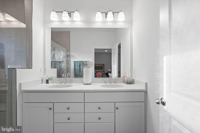 ensuite bathroom with double vanity, a shower stall, a sink, and ensuite bathroom