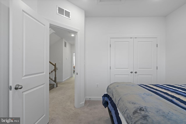 bedroom with baseboards, a closet, visible vents, and light colored carpet