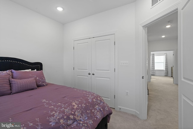 bedroom with recessed lighting, visible vents, a closet, and light colored carpet