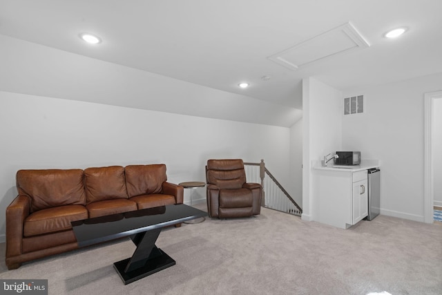 living room featuring recessed lighting, light colored carpet, visible vents, vaulted ceiling, and attic access